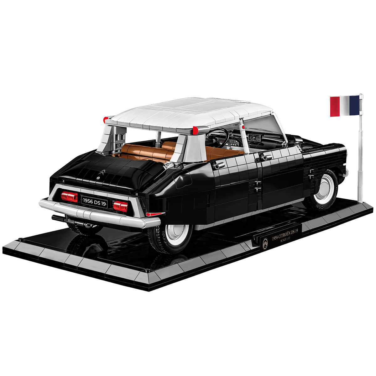 Tył modelu Citroëna DS 19 na podstawce ekspozycyjnej z francuską flagą